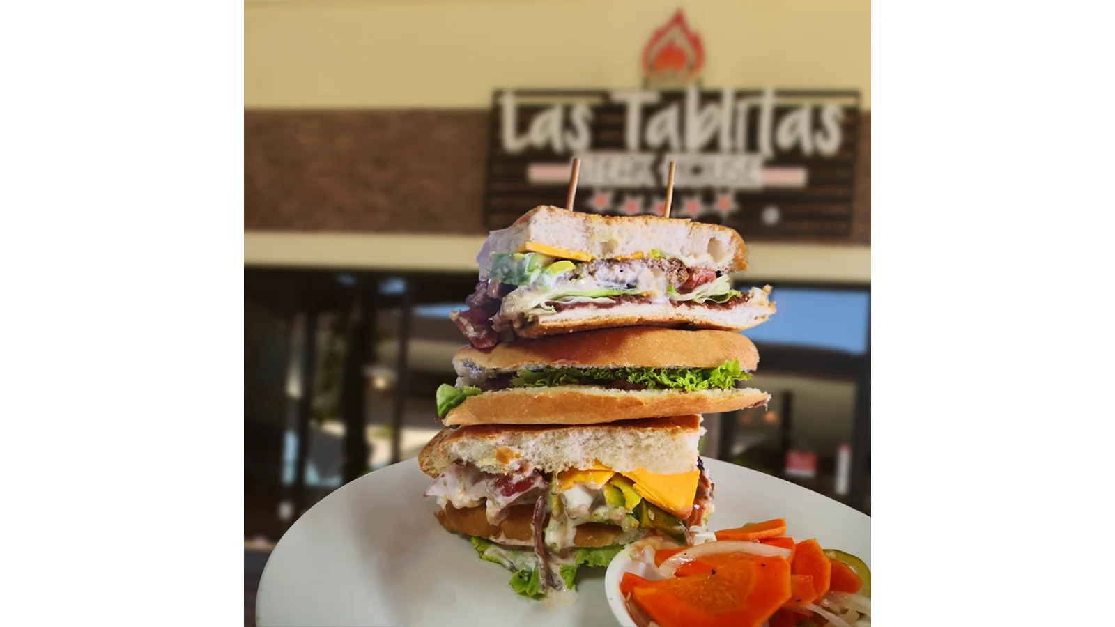 Fotografía de producto de Las Tablitas Steak House con un sándwich frente al restaurante